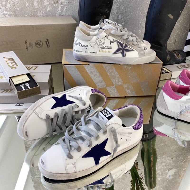 white S*per-star sneakers with blue star and glittery heel tab